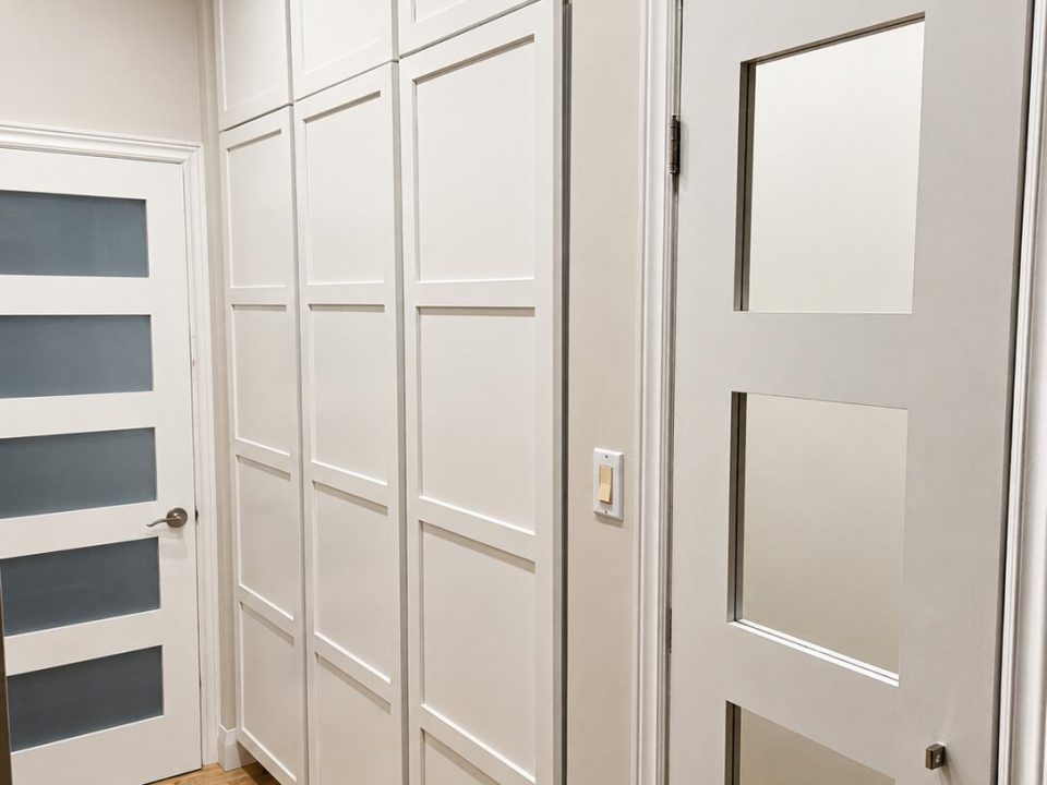 White painted shaker multi panel doors on hallway closets