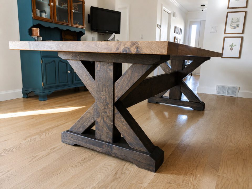 White oak book match laminated table with breadboard ends and X post timber trestle legs