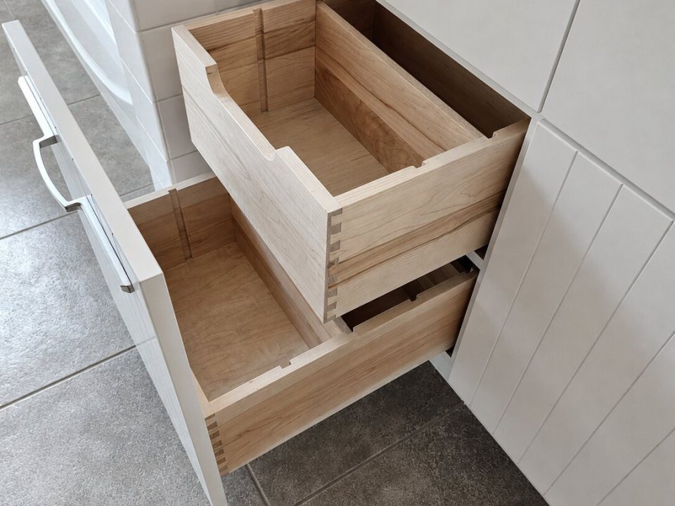 Hidden pull out dovetail drawers in a white bathroom vanity